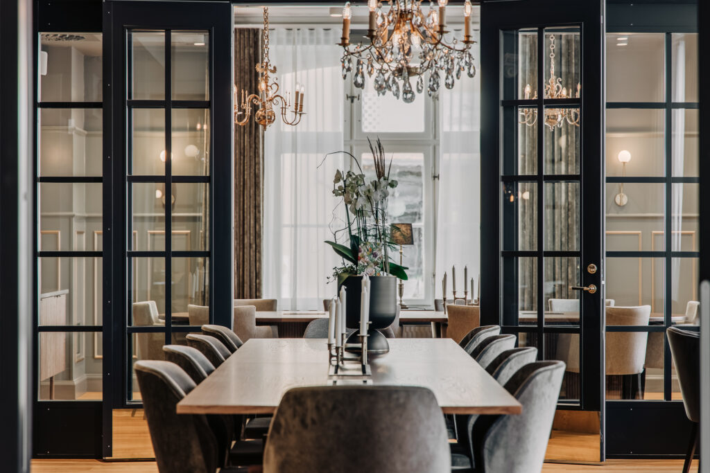 Elegant matsal med glasväggar och kristallkrona