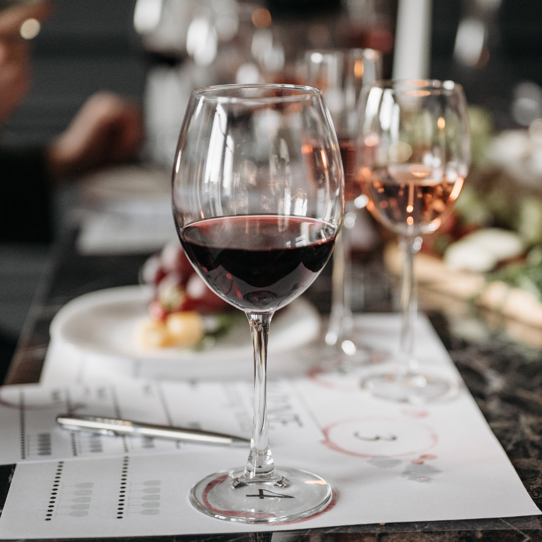 Glas rödvin på restaurangbord med suddig bakgrund